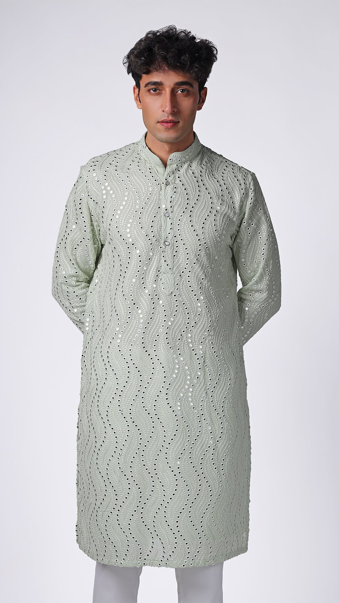 Detailed view of Mint Green Kurta, highlighting patterned mirror embroidery. Model styled with white slim trousers