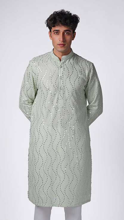 Detailed view of Mint Green Kurta, highlighting patterned mirror embroidery. Model styled with white slim trousers