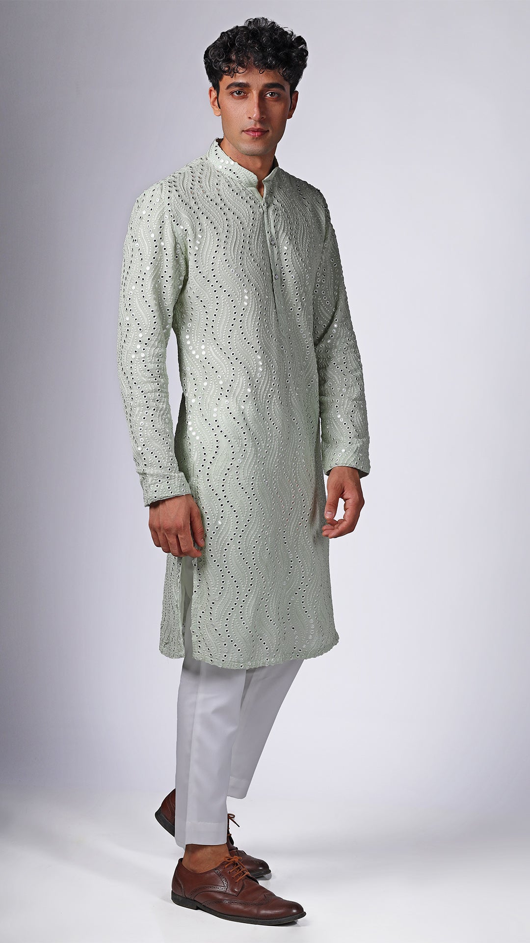 Side view of Mint Green Kurta with Patterned Mirror Embroidery, worn with white slim trousers and white sneakers