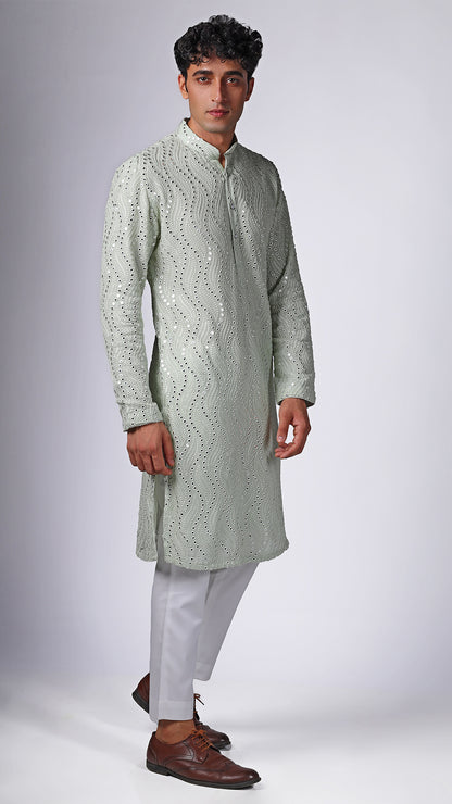 Side view of Mint Green Kurta with Patterned Mirror Embroidery, worn with white slim trousers and white sneakers