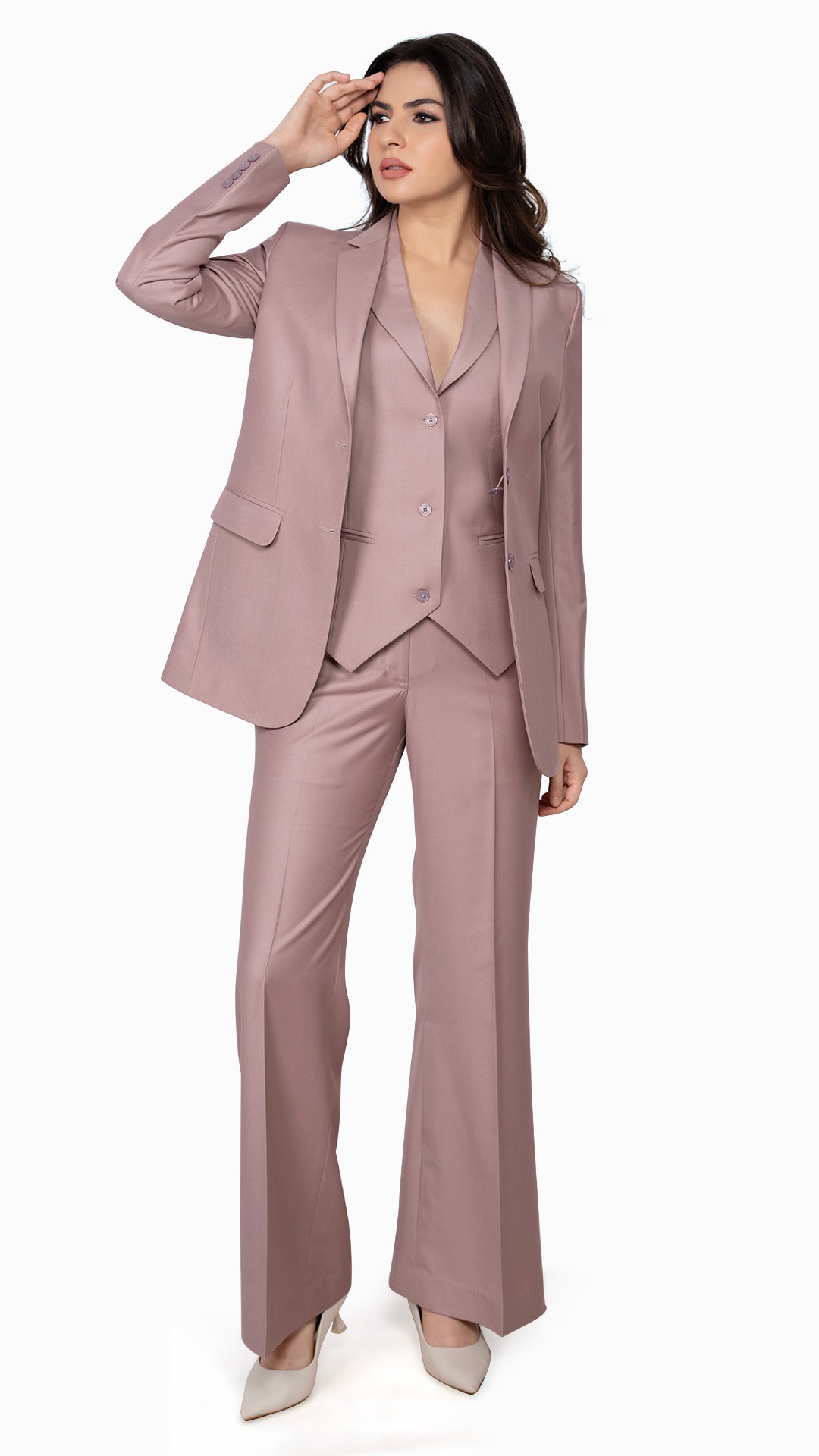 A contemporary three-piece suit featuring a single-breasted blazer, three-button notch lapel waistcoat, and bell-bottom trousers in a soft onion pink hue.

