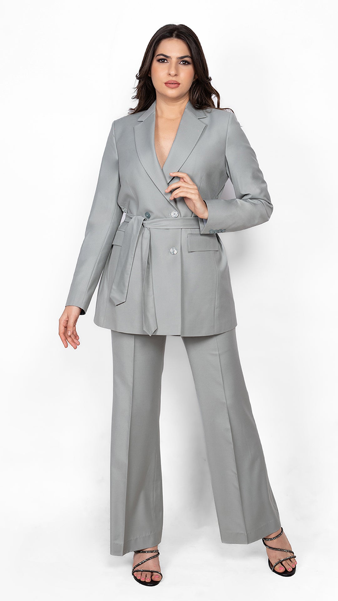 A sophisticated suit in mint green, featuring a notch lapel, belted waist, and precisely tailored trousers for effortless style.