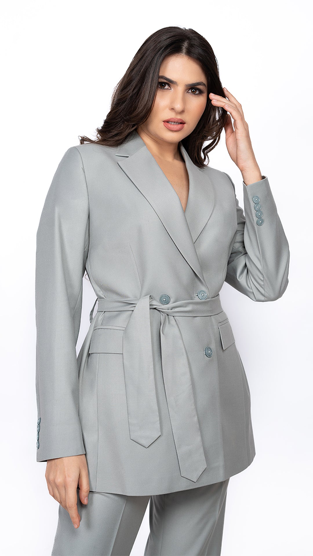 A tailored mint green blazer featuring a sharp notch lapel and a cinched belted waist, creating a structured yet feminine silhouette.