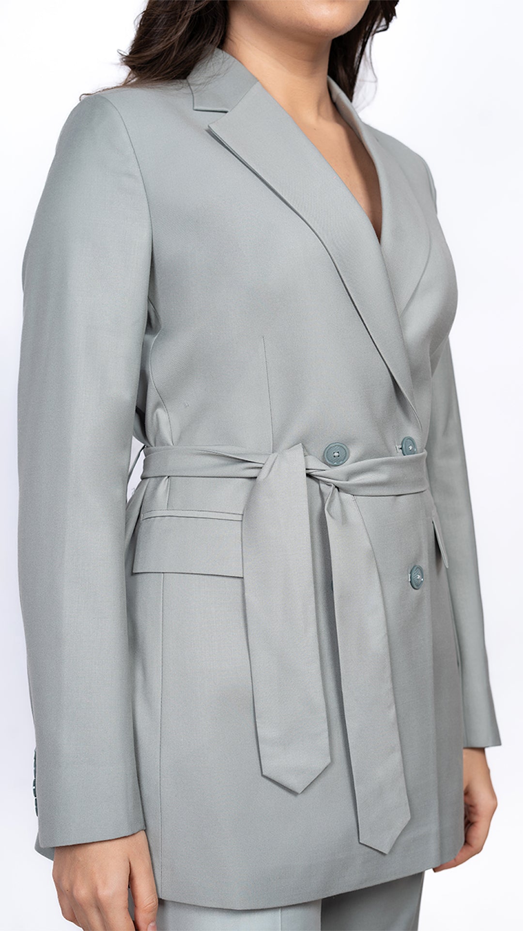 A close-up of the belted waist on the mint green blazer, showcasing its structured yet flattering fit for an elevated power dressing aesthetic.
