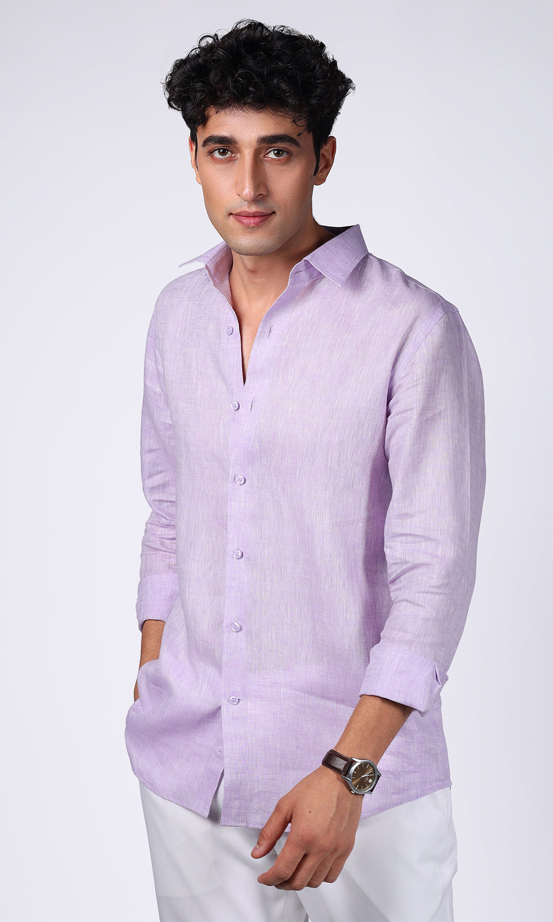 Model in a lavender linen shirt, standing with hands in pockets, showcasing a casual elegance.