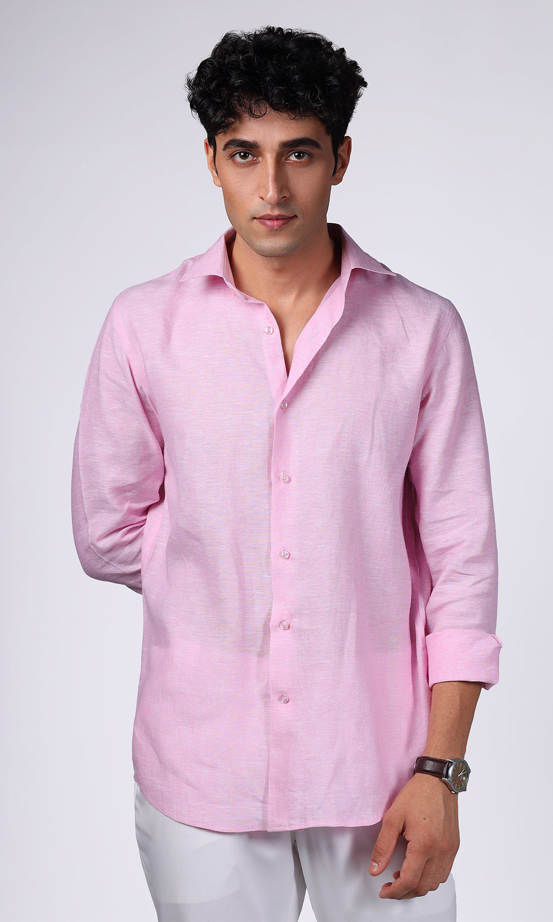 Close-up of a pink linen shirt on a model, emphasizing the deep, rich color and fabric quality