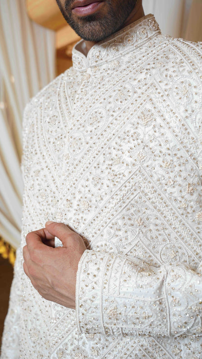 Close-up of a person wearing a white embroidered traditional outfit.