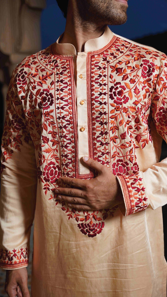 Traditional embroidered kurta with intricate patterns on a plain background