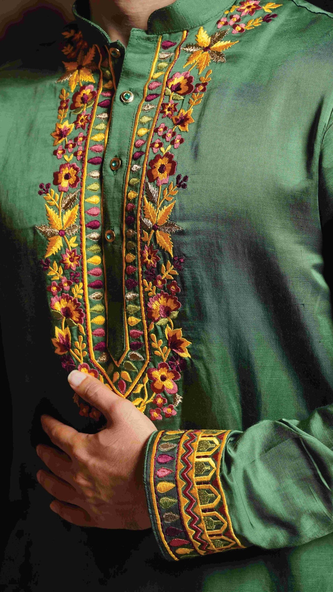 Close-up of a green embroidered garment with colorful patterns