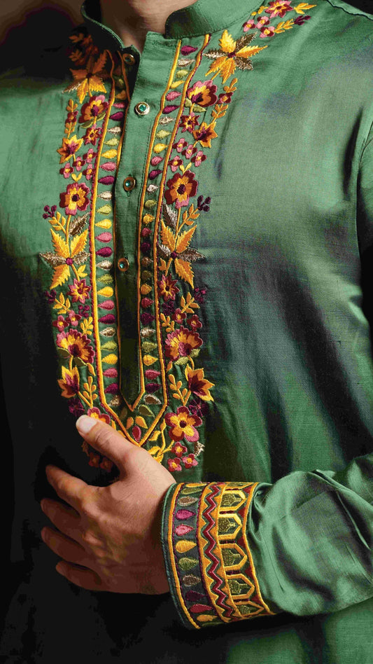 Close-up of a green embroidered garment with colorful patterns